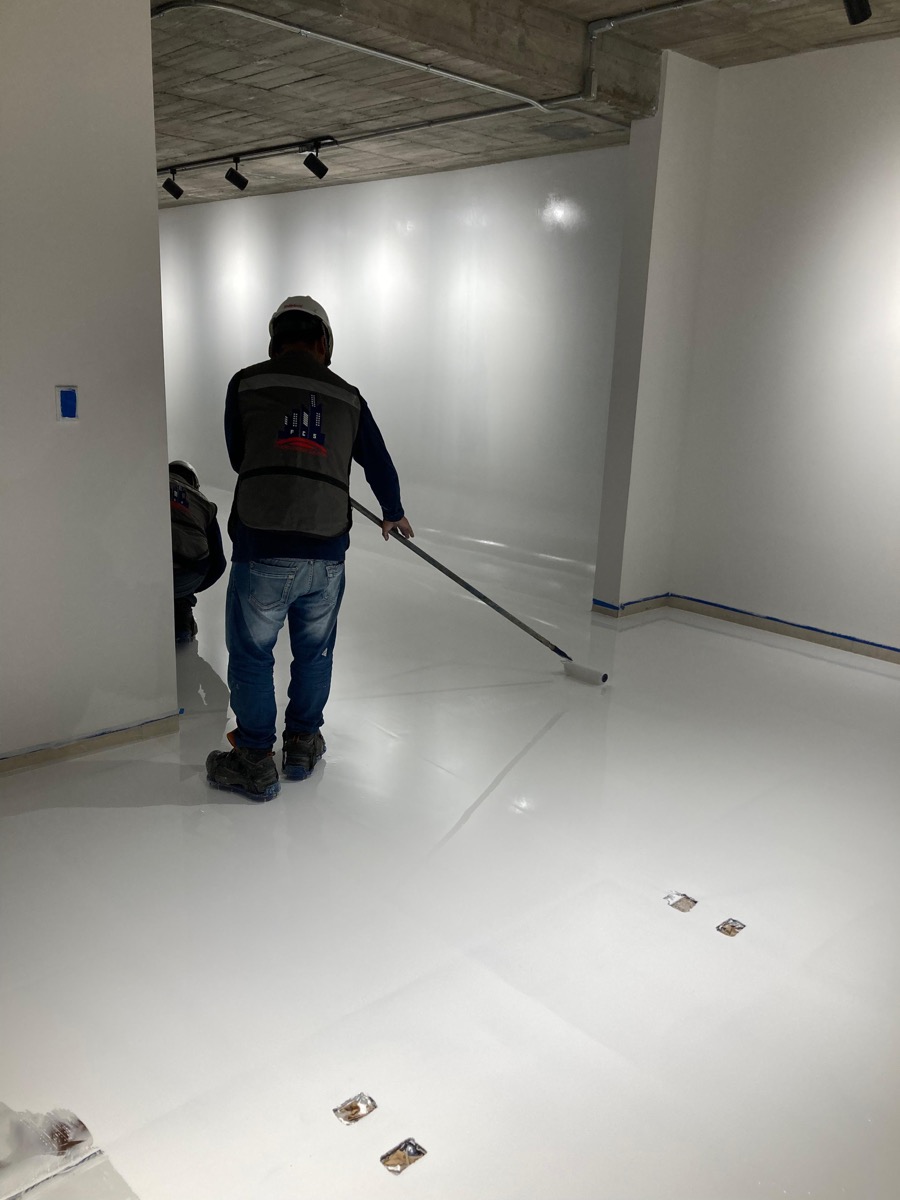 Equipo aplicando recubrimiento epóxico en piso comercial